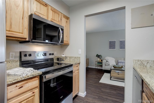 kitchen featuring light stone counters, baseboards, dark wood-style flooring, light brown cabinetry, and appliances with stainless steel finishes