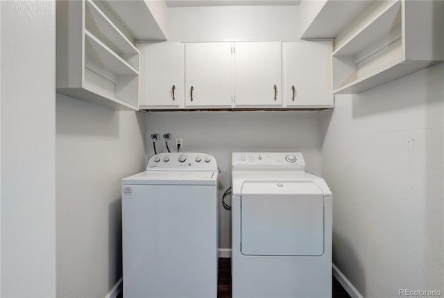 clothes washing area with cabinet space and independent washer and dryer