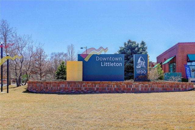 community / neighborhood sign featuring a yard