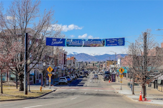 view of road with traffic signs, curbs, street lighting, and sidewalks