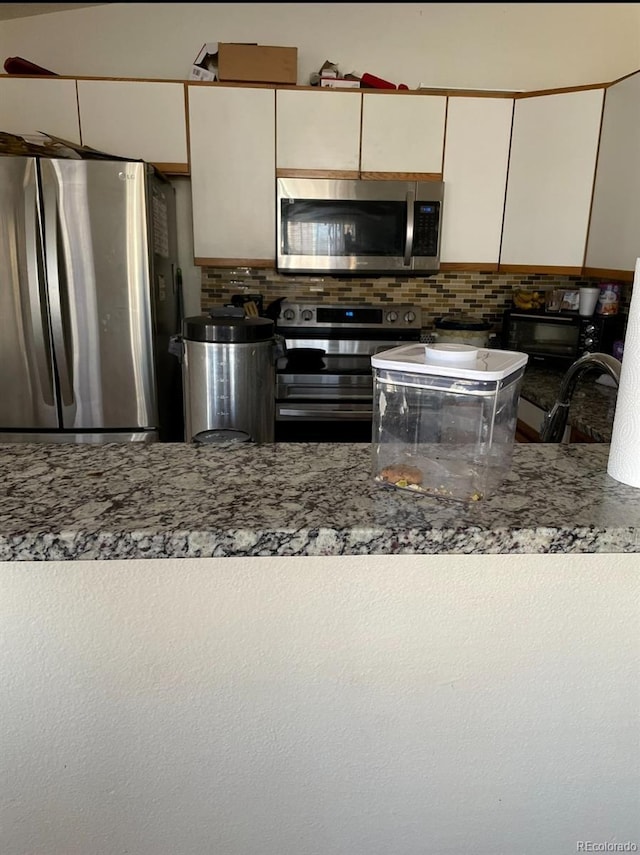 kitchen with sink, white cabinets, decorative backsplash, and stainless steel appliances