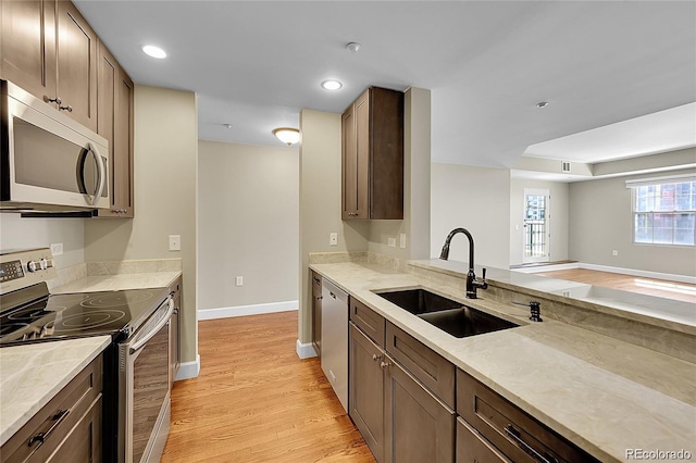 300 W 11th Ave Unit 8C, Denver, CO 80204 - kitchen with appliances with stainless steel finishes, light wood finished floors, light stone countertops, and recessed lighting