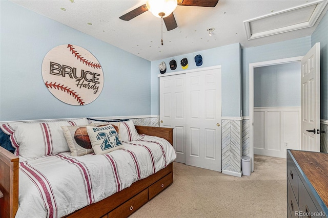 carpeted bedroom with ceiling fan and a closet