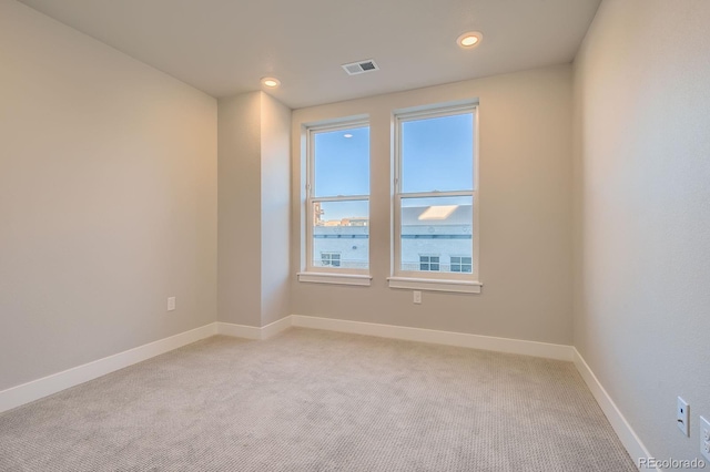unfurnished room featuring light carpet, baseboards, and recessed lighting