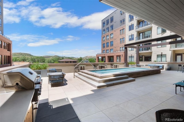 view of patio with a community pool, a grill, and a mountain view