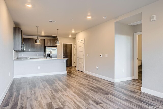 20 Wilcox St Unit 316, Castle Rock, CO 80104 - kitchen featuring appliances with stainless steel finishes, light wood-style flooring, light countertops, decorative backsplash, and a peninsula