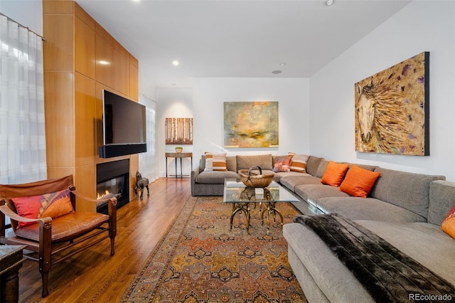 living room with a large fireplace and hardwood / wood-style floors