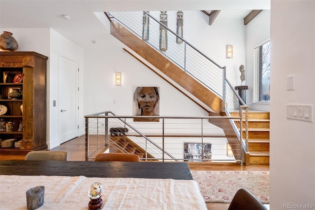 staircase with hardwood / wood-style floors and beam ceiling