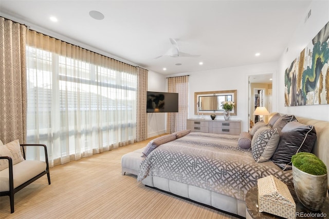 bedroom featuring multiple windows, light colored carpet, and ceiling fan