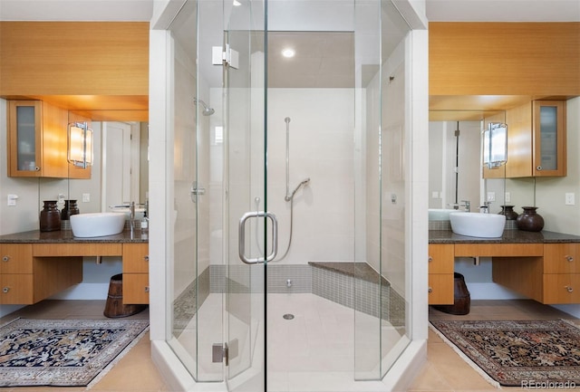 bathroom featuring tile patterned floors, a shower with door, and vanity