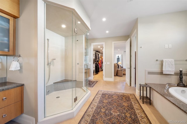 bathroom featuring tile patterned floors, vanity, and shower with separate bathtub