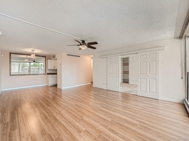 unfurnished living room featuring visible vents, light wood-style flooring, a ceiling fan, a textured ceiling, and baseboards