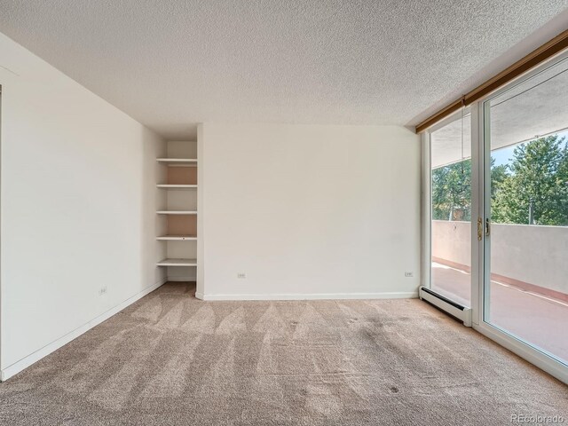 empty room featuring a baseboard radiator, floor to ceiling windows, baseboards, and light colored carpet