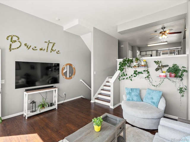 living area featuring stairway, baseboards, wood finished floors, and a ceiling fan