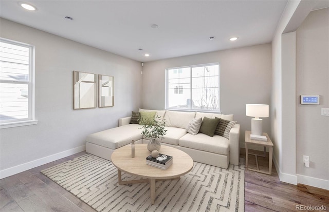 living room with baseboards, wood finished floors, and recessed lighting