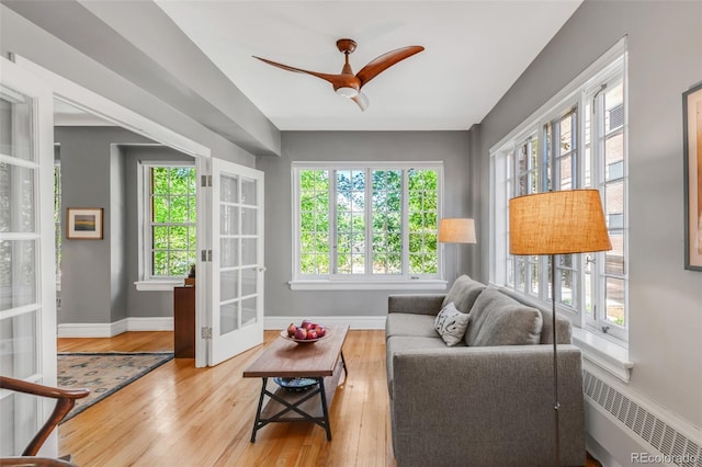 99 S Downing St Unit 105, Denver, CO 80209 - living room with wood finished floors, ceiling fan, french doors, and radiator heating unit