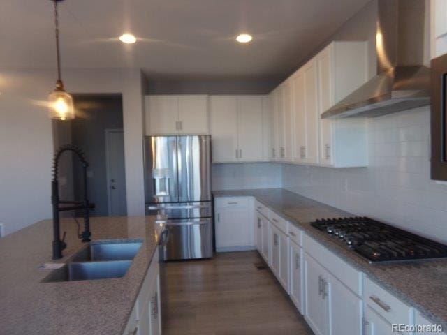 kitchen with white cabinetry, sink, wall chimney exhaust hood, and appliances with stainless steel finishes