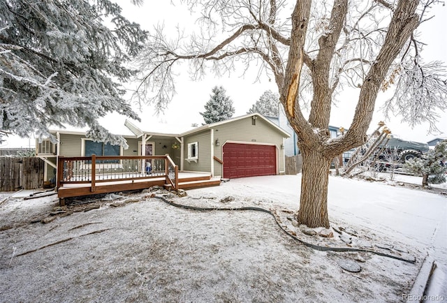 ranch-style home featuring a garage, fence, and a deck