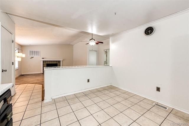 unfurnished room featuring a ceiling fan, visible vents, a fireplace, and baseboards