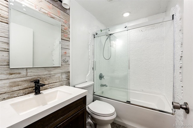 bathroom with toilet, enclosed tub / shower combo, and vanity