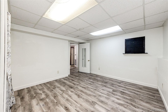 finished basement with a drop ceiling, wood finished floors, and baseboards