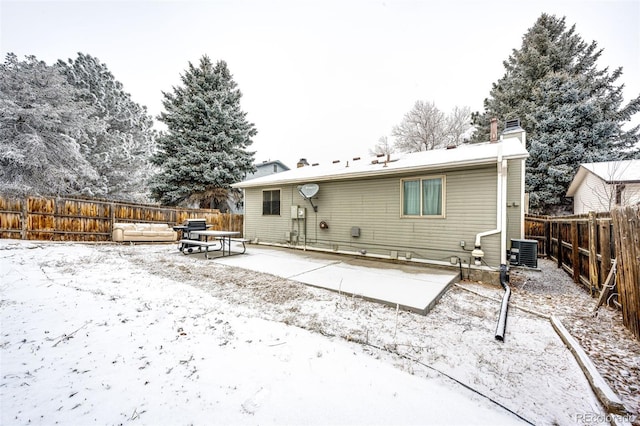 back of property with a chimney, a fenced backyard, a patio area, and cooling unit