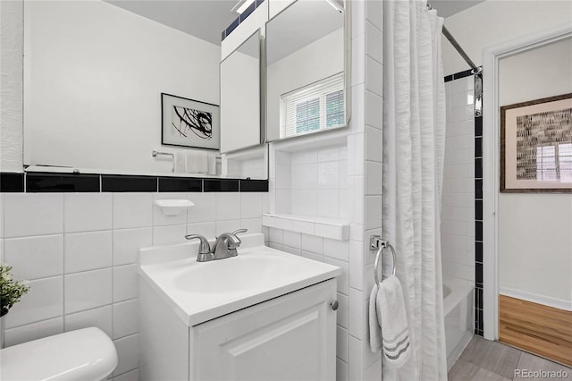 797 W Briarwood Ave, Littleton, CO 80120 - bathroom featuring tile walls, toilet, vanity, and shower / tub combo