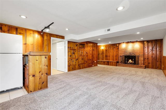 797 W Briarwood Ave, Littleton, CO 80120 - unfurnished living room with wooden walls, a fireplace, recessed lighting, light carpet, and light tile patterned floors