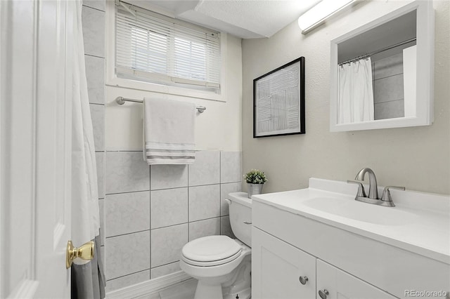 797 W Briarwood Ave, Littleton, CO 80120 - bathroom with toilet, vanity, and tile walls