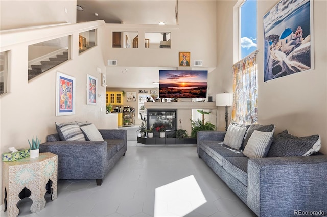 20414 E 55th Pl, Denver, CO 80249 - living area with a fireplace with raised hearth, tile patterned flooring, stairway, and a high ceiling