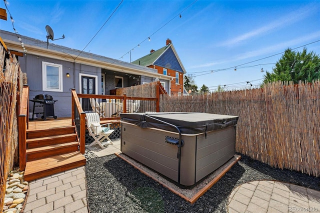 exterior space featuring a patio, a fenced backyard, a hot tub, and area for grilling