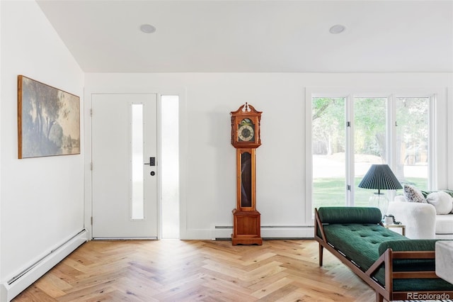 entrance foyer with baseboard heating, light parquet flooring, and lofted ceiling