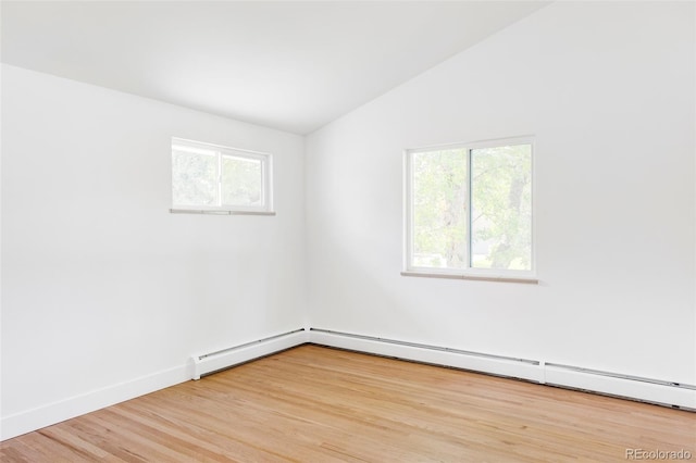 spare room featuring light hardwood / wood-style flooring, a baseboard heating unit, and lofted ceiling