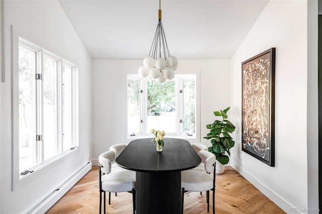 dining room featuring an inviting chandelier, a baseboard heating unit, and vaulted ceiling