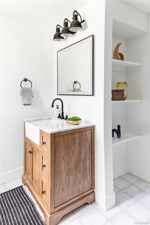 bathroom with tile patterned flooring, a washtub, and vanity