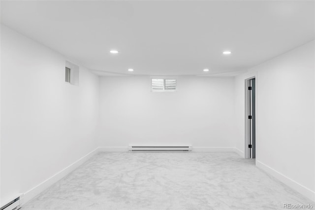 basement with carpet floors and a baseboard heating unit