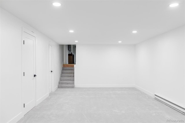 basement with a baseboard radiator and light colored carpet