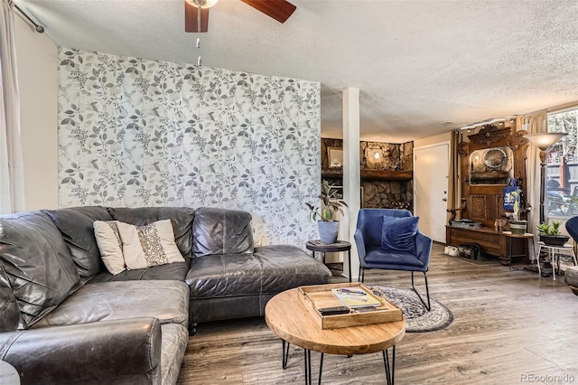 living area featuring ceiling fan, a textured ceiling, and wood finished floors
