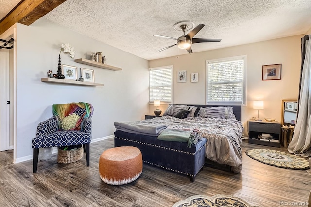 bedroom with a textured ceiling, wood finished floors, baseboards, and ceiling fan