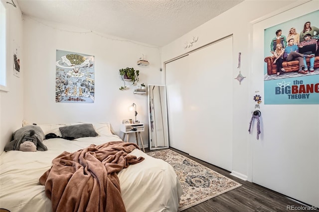 bedroom featuring wood finished floors and a textured ceiling