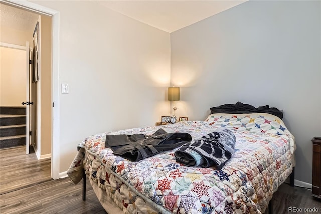 bedroom featuring wood finished floors and baseboards