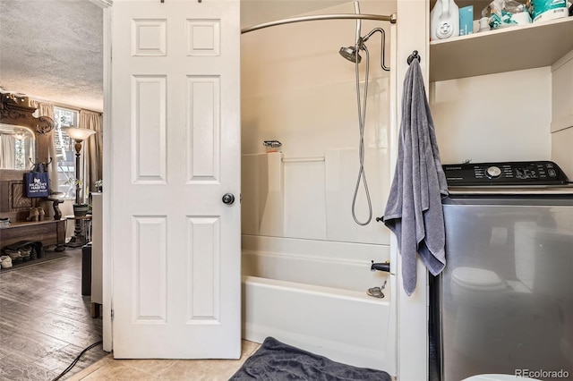 full bathroom with washer / clothes dryer, washtub / shower combination, and wood finished floors