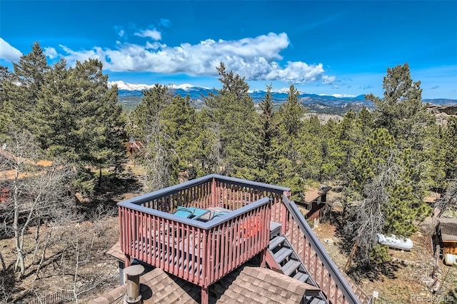 deck featuring a mountain view and a view of trees