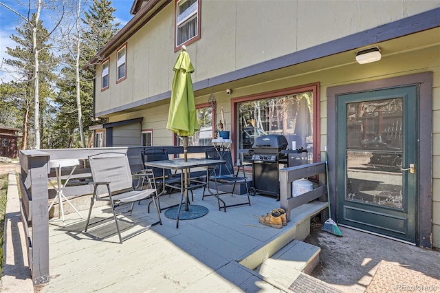 wooden deck with outdoor dining area and grilling area