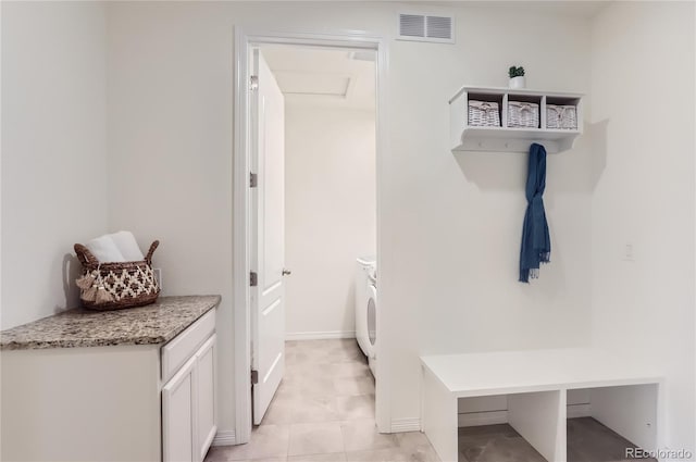 mudroom with light tile patterned floors and separate washer and dryer