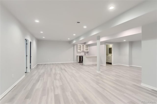 unfurnished living room with light wood-type flooring and beverage cooler