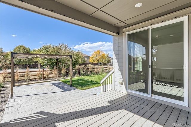 wooden terrace with a pergola, a patio area, and a lawn