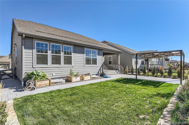 rear view of house featuring a pergola and a lawn