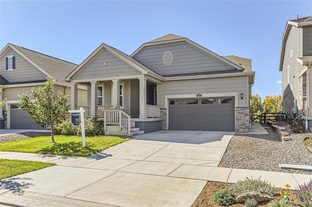 craftsman inspired home with central AC unit, covered porch, a front yard, and a garage