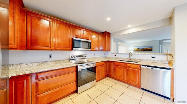 7270 Marmot Ridge Pl, Littleton, CO 80125 - kitchen with appliances with stainless steel finishes, light tile patterned floors, light stone counters, and recessed lighting